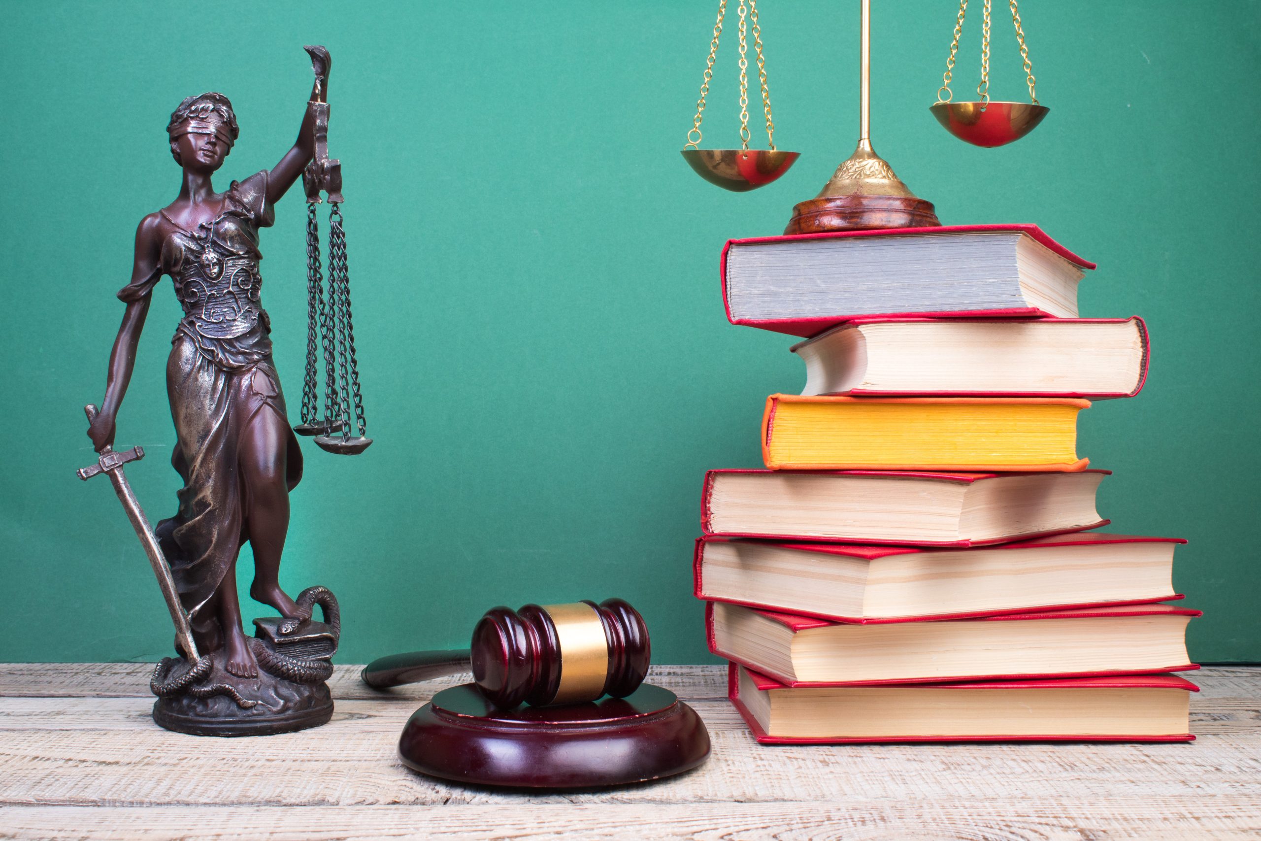 Conjunto de libros al lado de figura de justicia