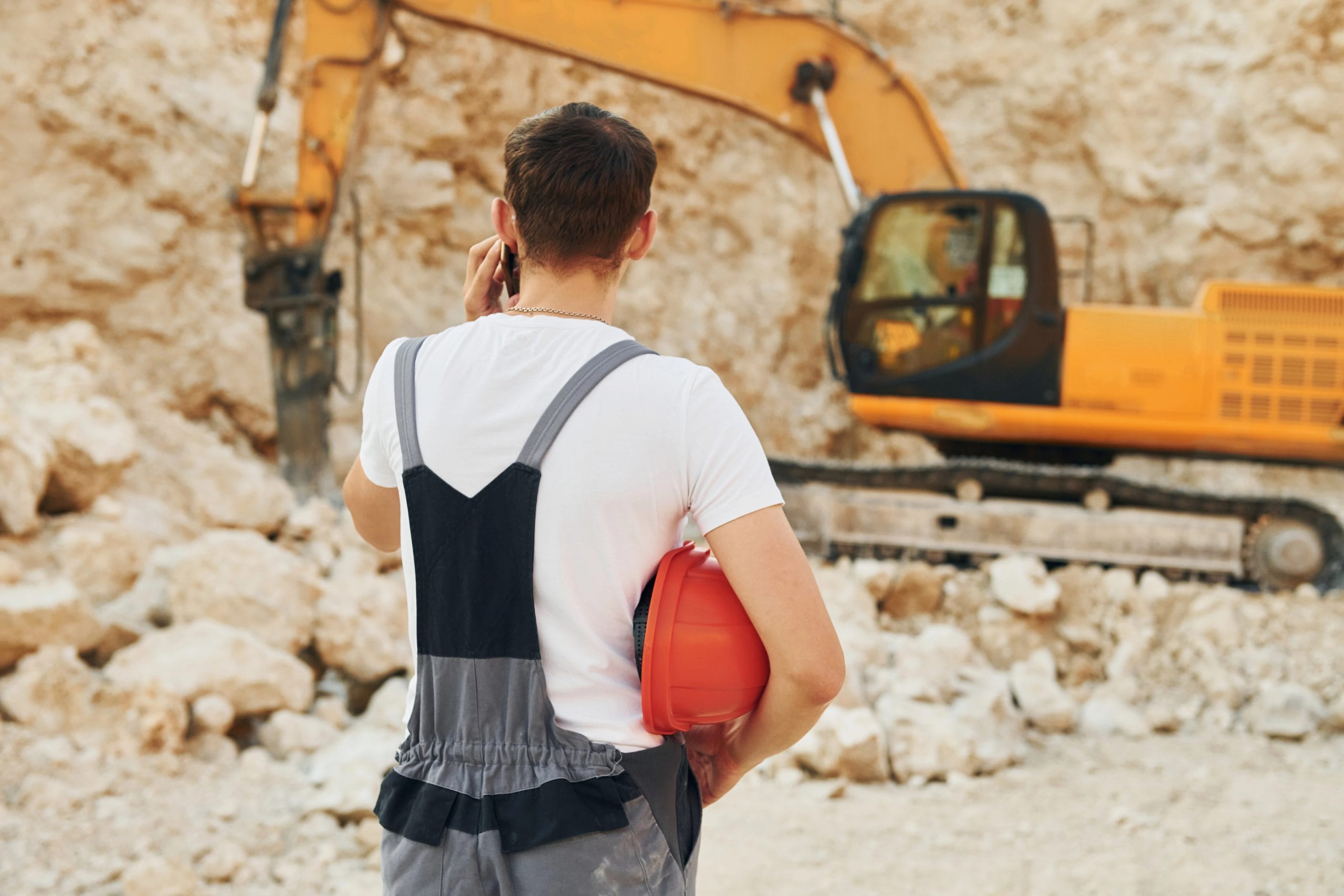 Excavadora junto a peón de obra